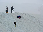 Manche machen den Abstieg mittels Rutschen auf dem Rucksack