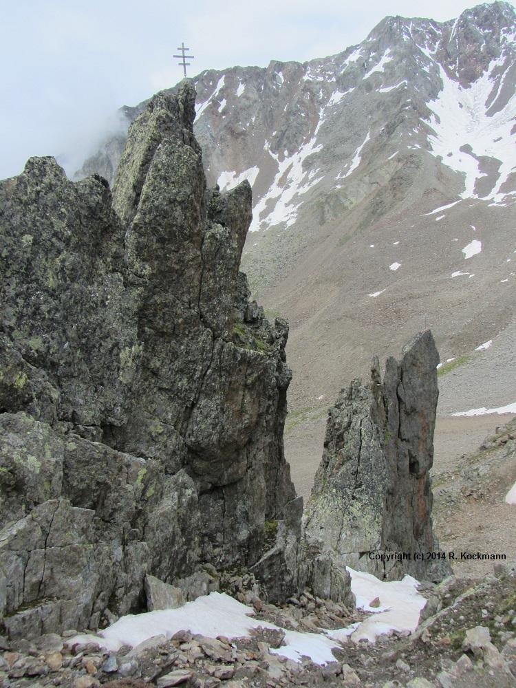 Ganz oben ein spitzer Felsen mit Gipfelkreuz